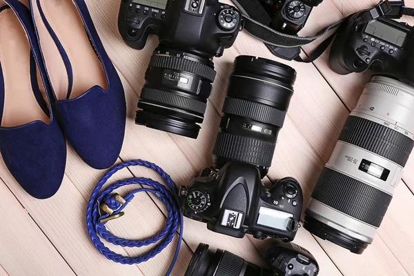 Caméras modernes avec chaussures féminines et ceinture sur table en bois, vue de dessus — Photo