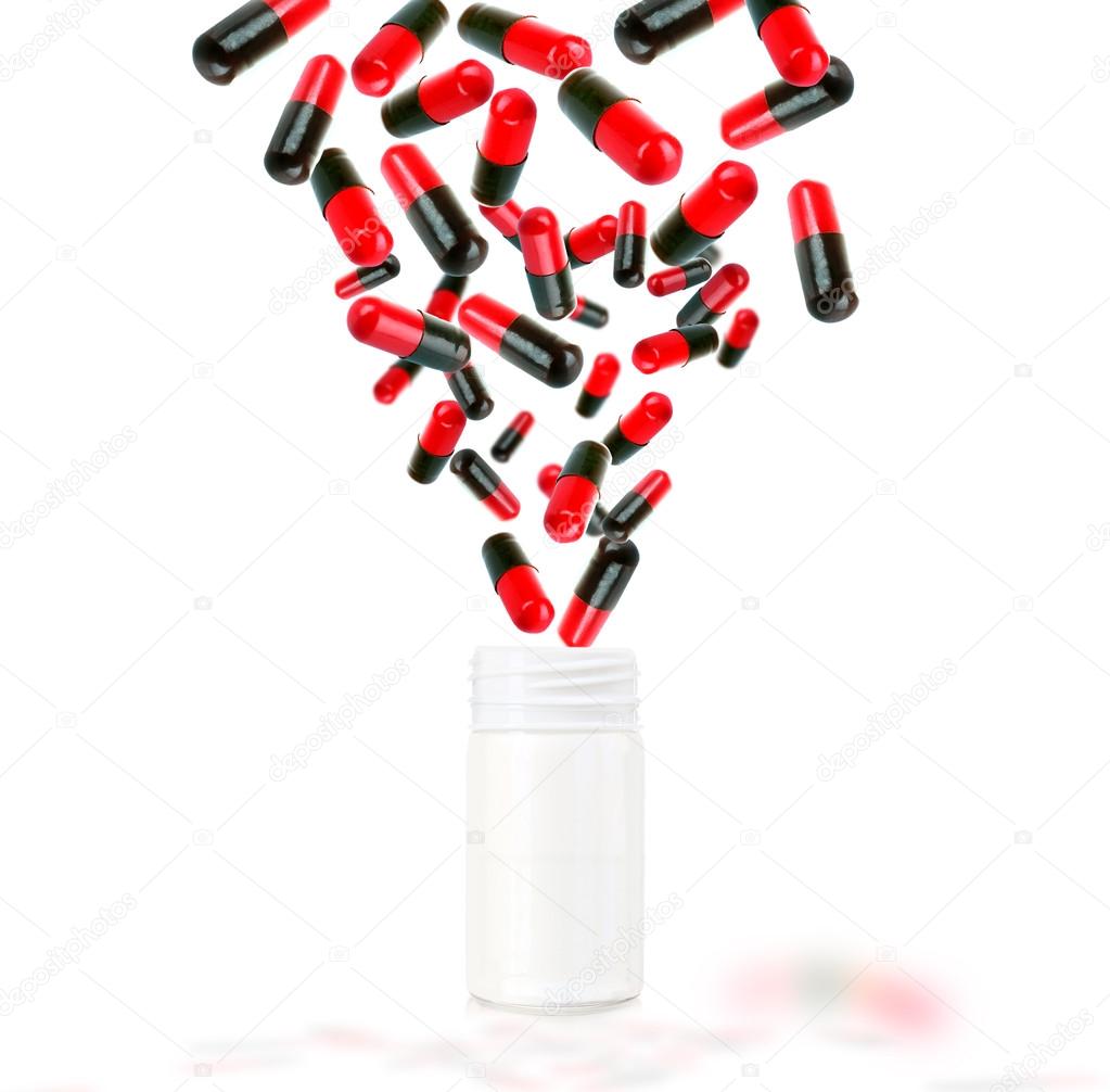 Bright color pills flying away from open plastic bottle isolated on white