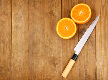 Turuncu ahşap zemin üzerine bıçakla yarısı