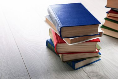 Ahşap zemin üzerine kitap yığınları