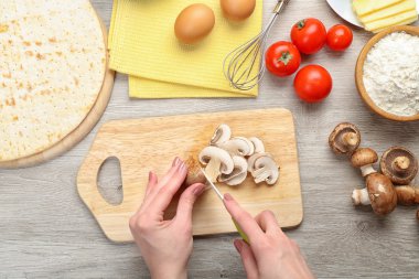 erkek pişirme pizza ahşap masa, closeup üzerinde eller