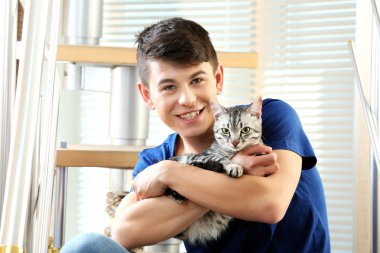 yakışıklı delikanlı ile evde basamaklarında oturan sevimli kedi