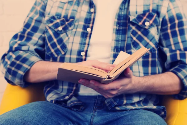 Jonge man lezen boek, close-up, op lichte achtergrond — Stockfoto