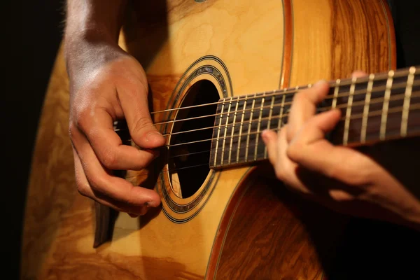 Young man playing on acoustic guitar close up — Stock Photo, Image