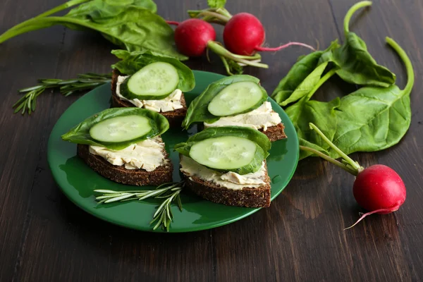 Deliciosos sándwiches con verduras y verduras sobre mesa de madera —  Fotos de Stock