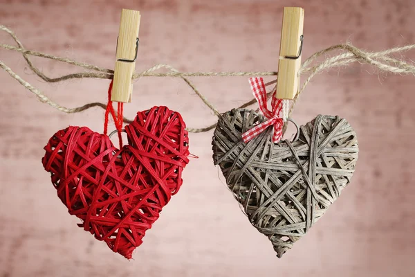 Corazones brillantes colgando de una cuerda sobre un fondo de madera — Foto de Stock