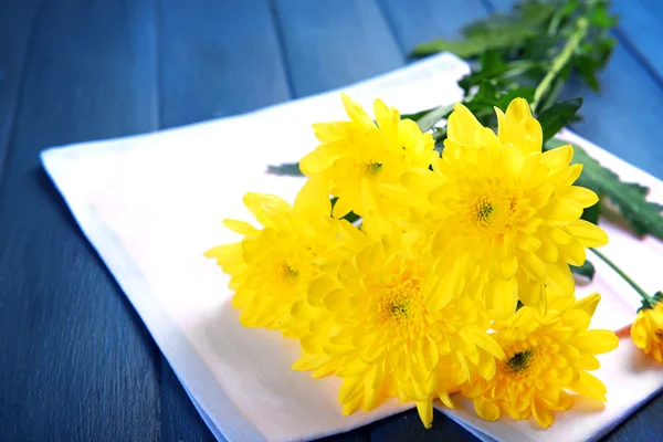 Mooi boeket van gele chrysanten met servet op houten tafel — Stockfoto