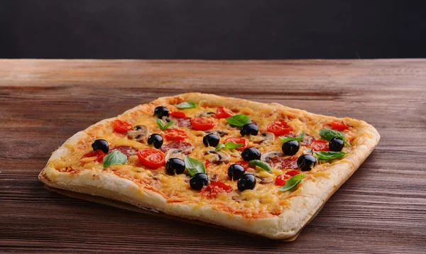 Delicious homemade pizza on table on black background