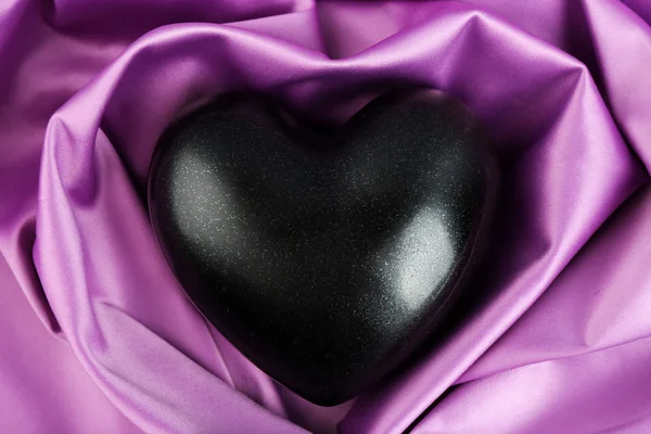 Corazón negro sobre fondo de tela — Foto de Stock