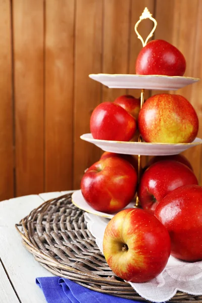 Leckere reife Äpfel auf Serviertablett auf Holzuntergrund — Stockfoto