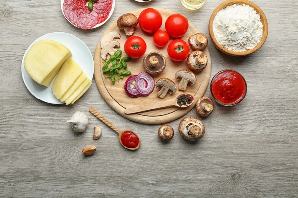 Ahşap masa, üstten görünüm üzerinde pizza yemek pişirmek için malzemeler — Stok fotoğraf