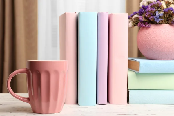 Boeken, cup en plant op houten tafel, close-up — Stockfoto