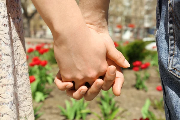 Couple holding hands on blurred background — Stock Photo, Image