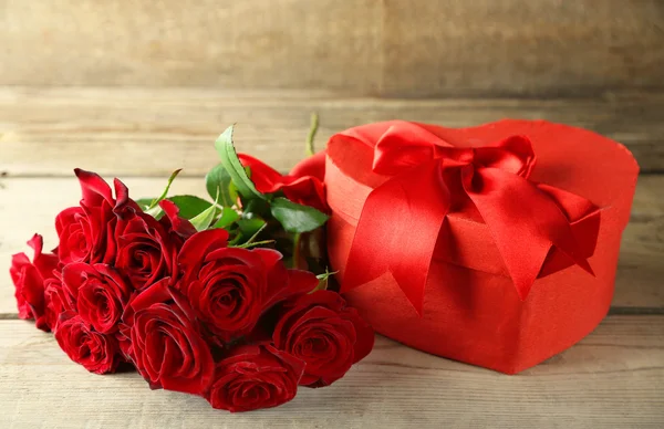 Herzförmige Valentinstag Geschenkschachtel mit roten Rosen auf altem Holztisch — Stockfoto