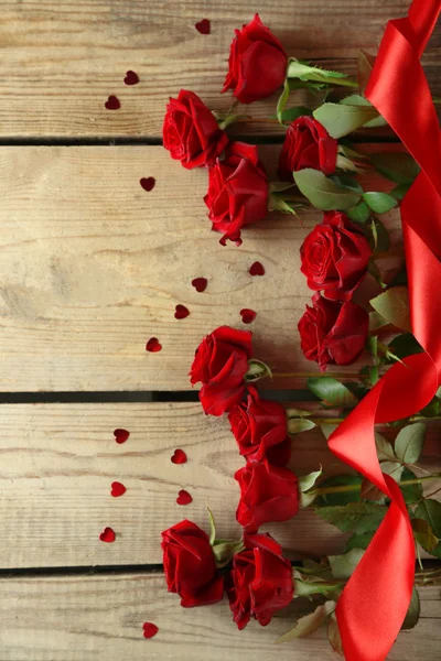 Belle rose rosse su vecchio tavolo di legno — Foto Stock