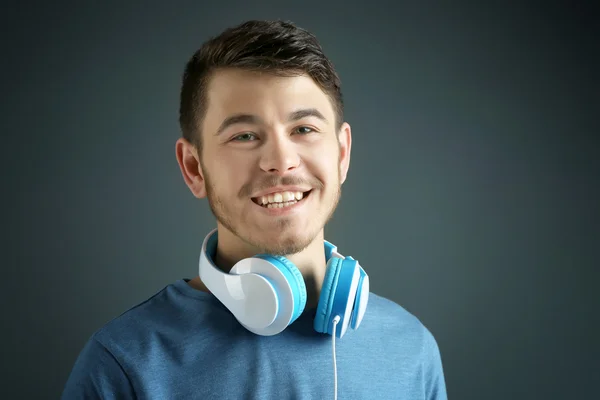 Joven guapo con auriculares sobre fondo gris —  Fotos de Stock