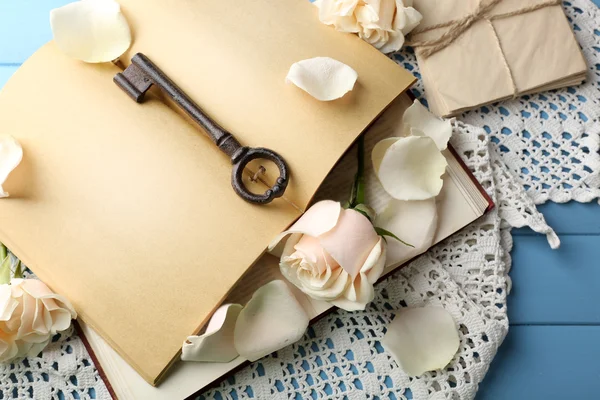 Fresh roses with old book and letters on color wooden table background. Vintage concept — Stock Photo, Image