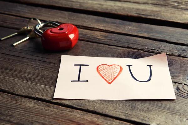 Written message with decorative heart on wooden table close up — Stock Photo, Image