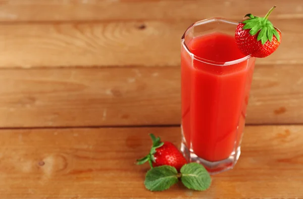 Ποτήρι φρέσκο χυμό φράουλα σε ξύλινα φόντο — Φωτογραφία Αρχείου