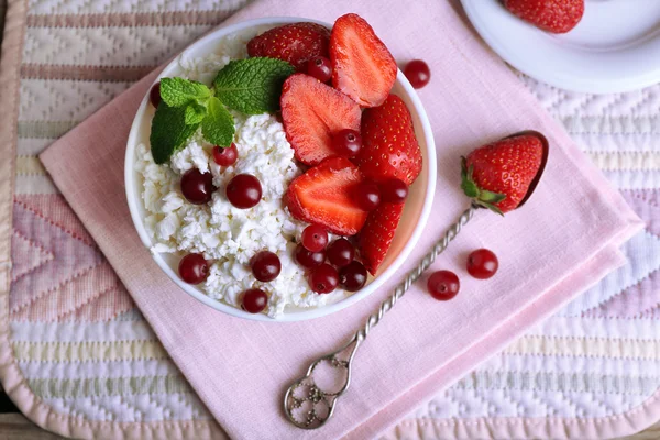 Bowl of cottage cheese with strawberry and cranberry on table, closeup — Stock Photo, Image