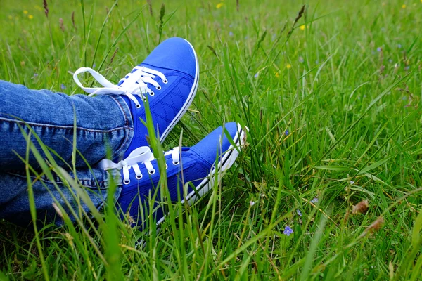 Pies femeninos en zapatos de goma sobre hierba verde —  Fotos de Stock