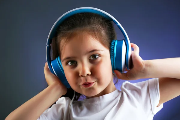 Vacker liten flicka lyssna på musik på Cologne bakgrunden — Stockfoto