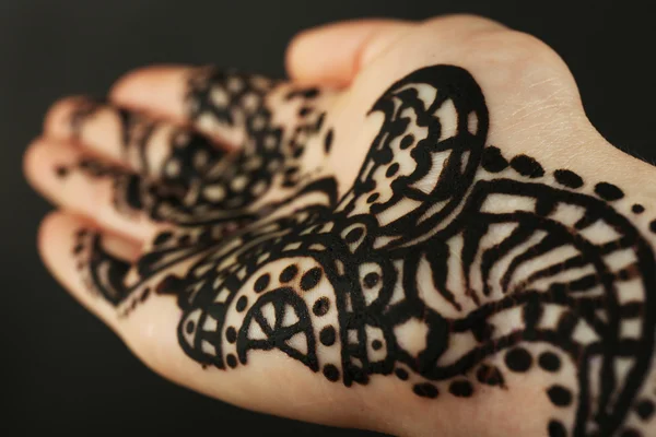 Closeup image of henna on female hand on dark background — Stock Photo, Image