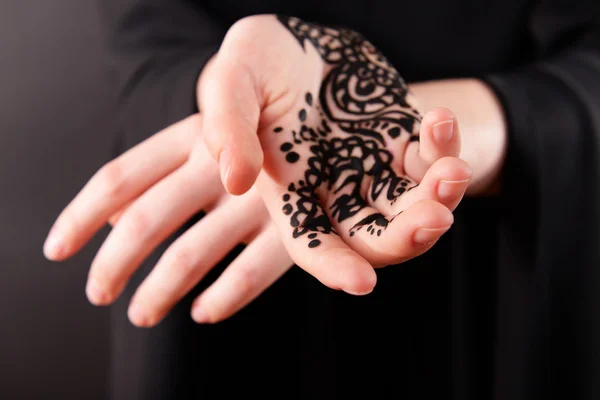 Imagem de close-up de henna na mão feminina no fundo escuro — Fotografia de Stock