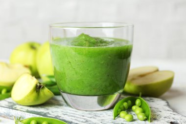 bezelye ve ahşap masa, closeup üzerinde elma ile sağlıklı yeşil smoothie