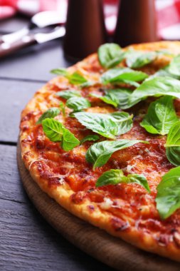 Pizza üzerinde ahşap masa, closeup fesleğen ile