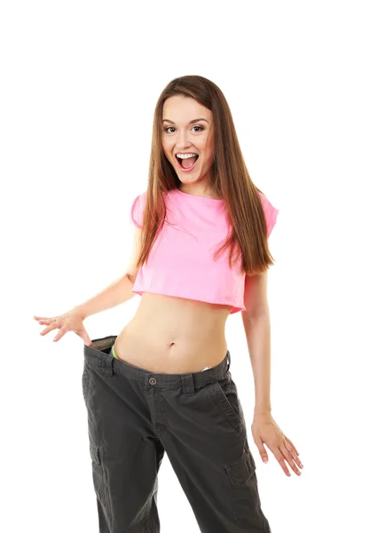 Young slim woman wearing too big pats isolated on white — Stock Photo, Image