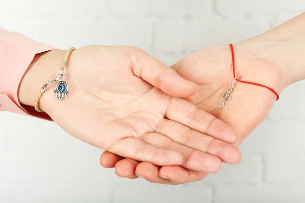 Two hands of friendship and religions symbols — Stock Photo, Image