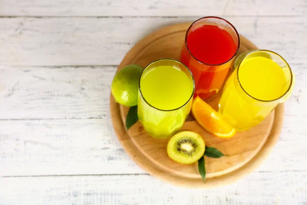 Verres de jus différent avec des fruits et menthe sur fond en bois — Photo