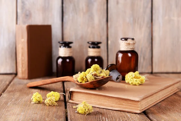 Libros antiguos con flores secas y botellas sobre fondo de madera —  Fotos de Stock