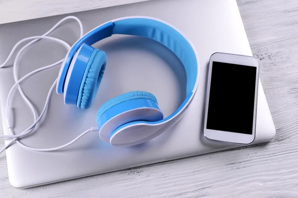 Headphones with laptop on table close up — Stock Photo, Image