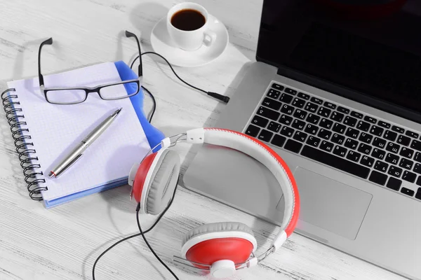 Local de trabalho com fones de ouvido na mesa de perto — Fotografia de Stock