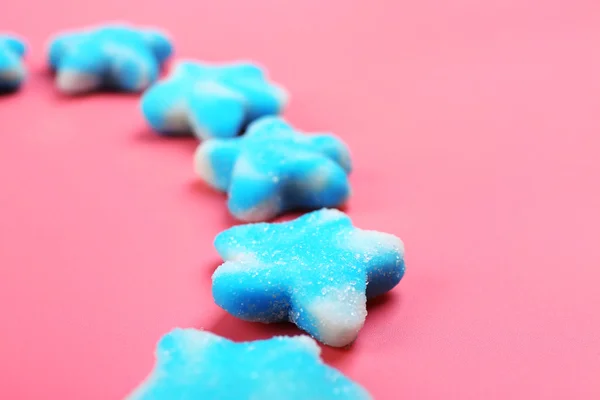 Blaue Bonbons in Form von Sternen auf rosa Hintergrund — Stockfoto