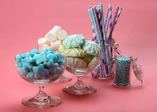 Caramelos esponjosos en cristalería sobre fondo rosa —  Fotos de Stock