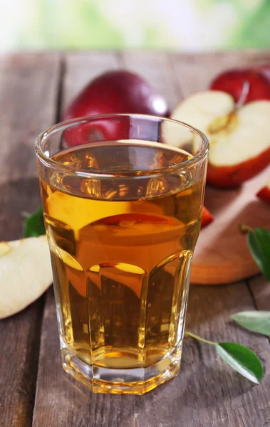Gelas jus apel dengan apel merah di atas meja kayu, closeup — Stok Foto