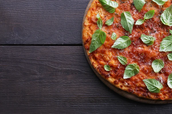 Pizza con albahaca sobre fondo de madera — Foto de Stock