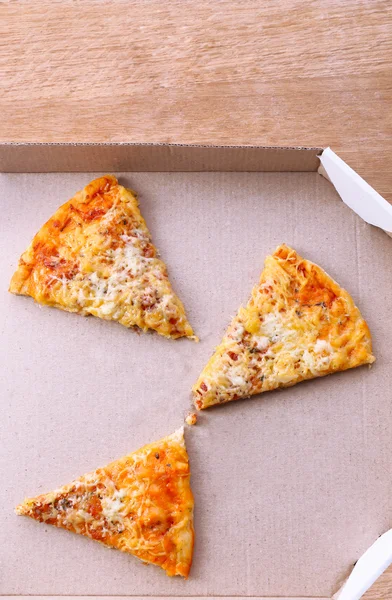 Pieces of pizza on cardboard background — Stock Photo, Image