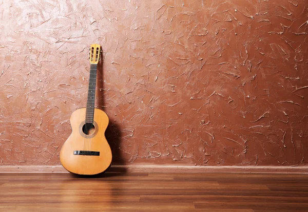 Guitarra acústica clássica no fundo da parede marrom — Fotografia de Stock