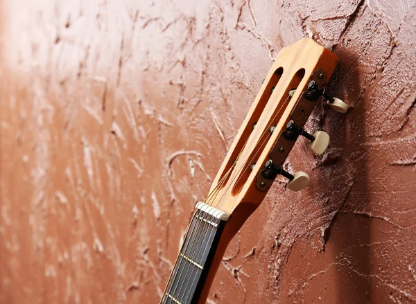 Klasická akustická kytara na pozadí hnědé stěny — Stock fotografie