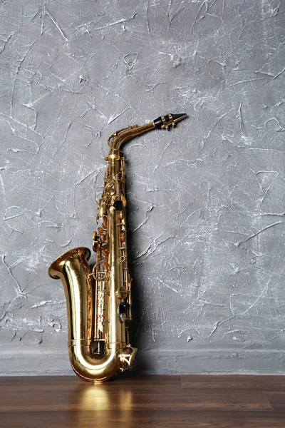 Saxophone doré sur fond mural gris — Photo