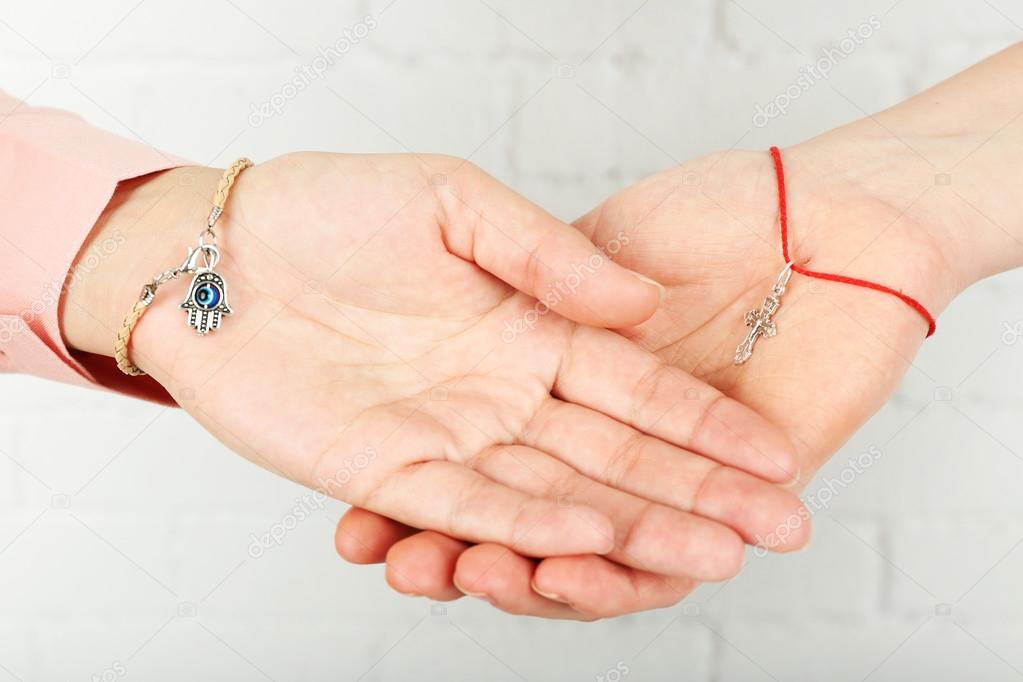 Two hands of friendship and religions symbols