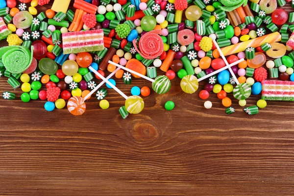 Ahşap arka planda renkli şekerler — Stok fotoğraf