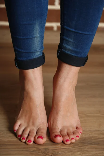 Gyönyörű női lábak, a fa padló háttér — Stock Fotó