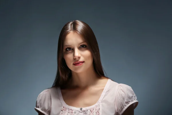 Portret van mooie jonge vrouw op donkere achtergrond — Stockfoto