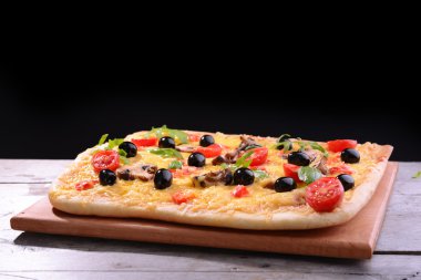 siyah arka plan üzerine masada lezzetli ev yapımı pizza