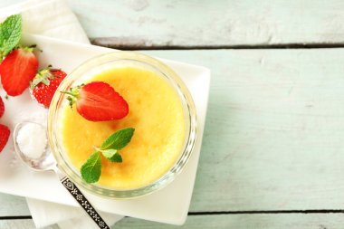 Creme brulee tatlısı peçeteye renk ahşap arka plan üzerinde taze çilek Çilek ile